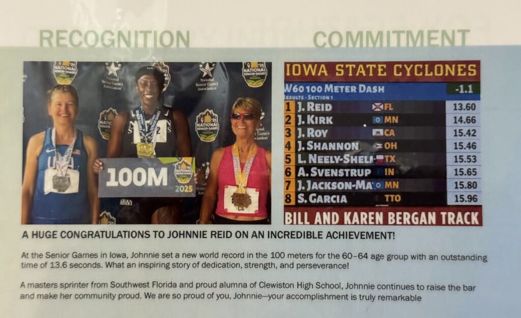 An image showing a celebration for athlete Johnnie Reid's world record at the Senior Games.On the left, a photo shows three female sprinters smiling on a podium, with the central athlete wearing gold medals under a "100M" graphic. The right side features a scoreboard labeled "IOWA STATE CYCLONES" and "W60 100 Meter Dash," ranking J. Reid first with a time of 13.60 seconds. Text at the bottom congratulates Johnnie Reid for setting a new world record in the 60–64 age group.